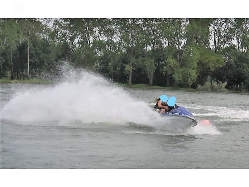 photo dun jet ski sur un lac avec deux personnes.